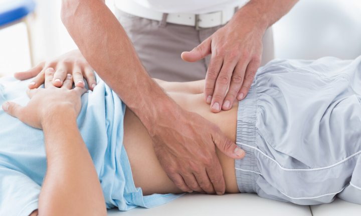 누운 환자의 허리 주변을 손으로 짚어 살피는 치료 장면